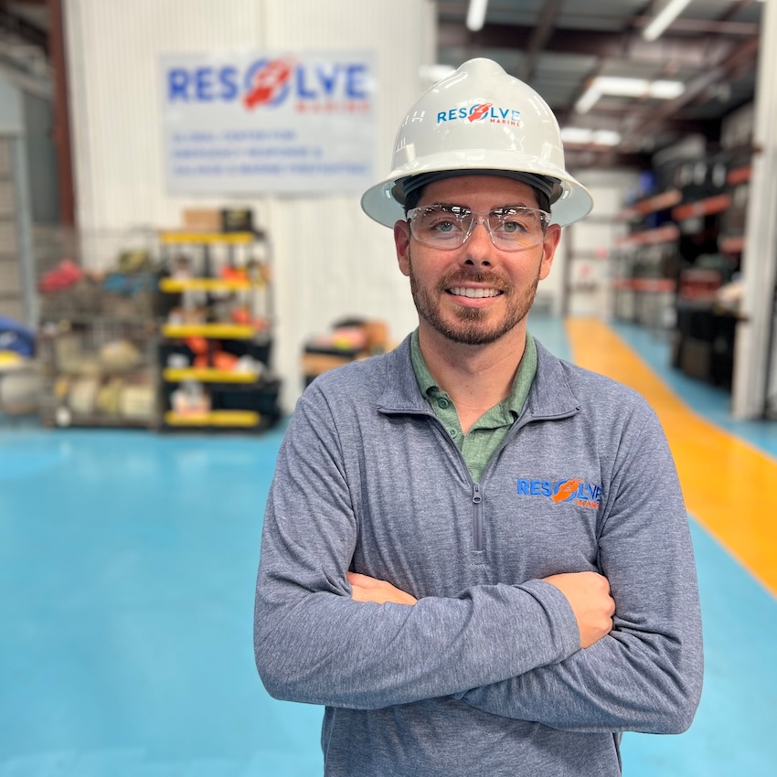 Photo of Matt Nadell in a warehouse setting with Resolve Marine logo on wall behind him.